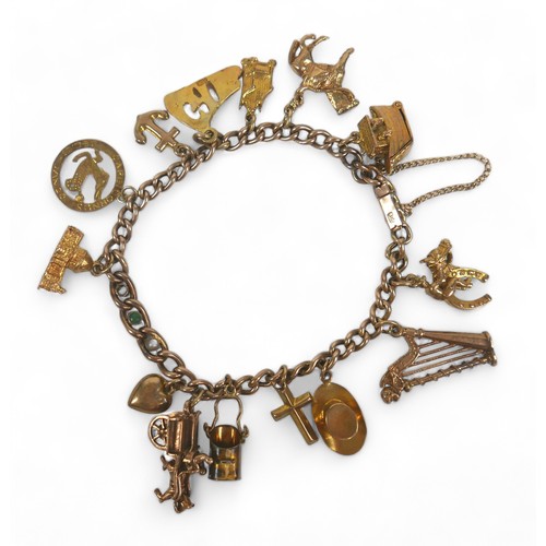 86 - A 9ct gold charm bracelet, with push clasp and safety chain, fourteen gold charms, including a horse... 