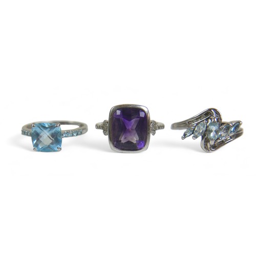 63 - A group of three ladies dress rings, comprising a a white gold and topaz ring, size P, a white gold ... 