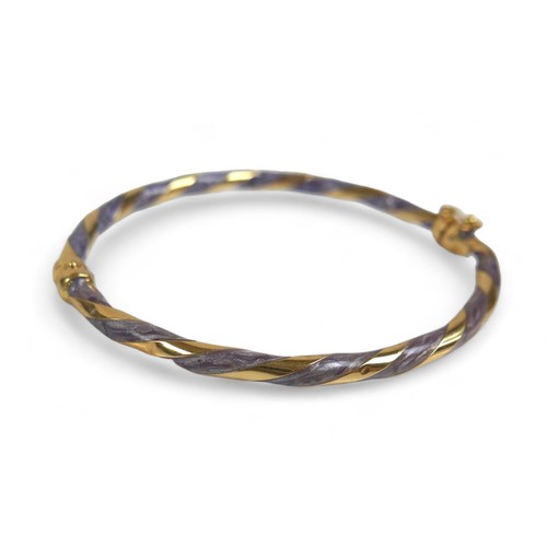 62 - An Italian 18ct yellow gold and enamel hinged bangle, in twisted design, 4mm wide, interior measurem... 