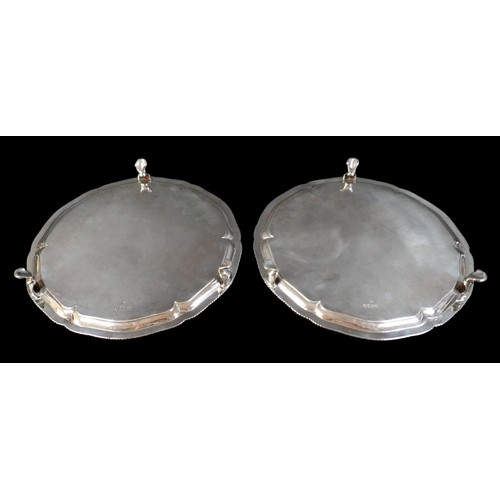 3 - A pair of George III silver salver trays, with scalloped rim and gadrooned edge, raised on three hoo... 