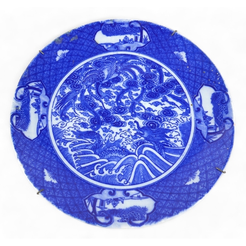 130 - A Chinese porcelain dish, late 19th century, decorated internally with a dragon and a phoenix fighti... 