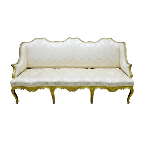 572 - A 19th century giltwood settee, three seater, with floral carved frame, upholstered in cream damask ... 