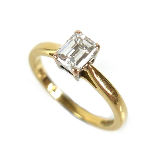 142 - An 18ct yellow gold and diamond solitaire ring, the emerald cut stone, 0.65ct, 5.5 by 4.3 by 2.9mm, ... 