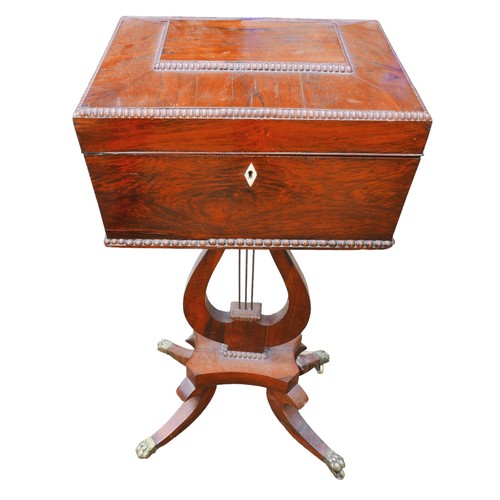 529 - A Regency rosewood teapoy, with four internal caddies, raised on a lyre support and quatrefoil splay... 