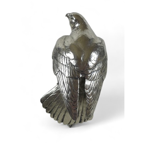 262 - A Keith Sherwin nickel resin sculpture of a falcon, perched on a branch, 17.5 by 20 by 24cm high.