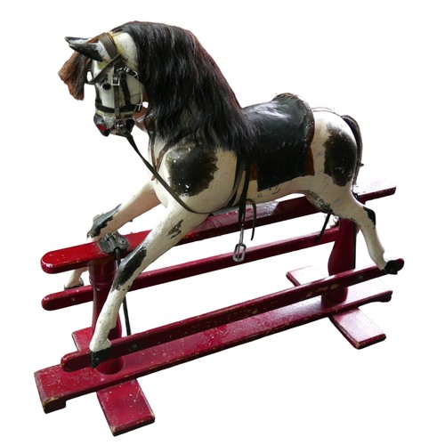 334 - A Victorian hand painted rocking horse, piebald pattern, with saddle and reins, upon a red trestle b... 