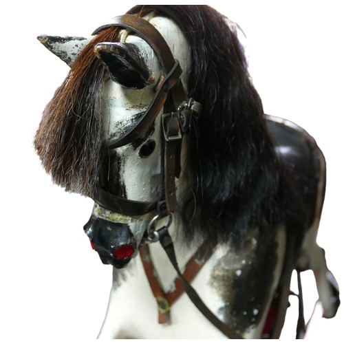 334 - A Victorian hand painted rocking horse, piebald pattern, with saddle and reins, upon a red trestle b... 