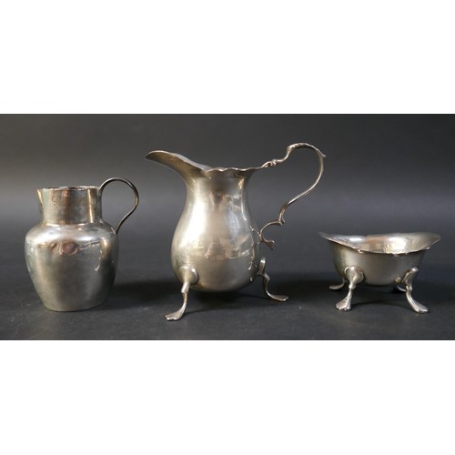 31 - A collection of silver items, comprising two jugs, four napkin rings, a salt and a pair of silver sw... 