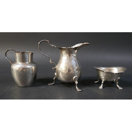 31 - A collection of silver items, comprising two jugs, four napkin rings, a salt and a pair of silver sw... 