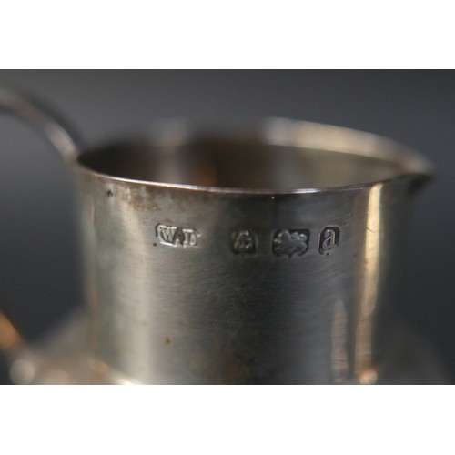 31 - A collection of silver items, comprising two jugs, four napkin rings, a salt and a pair of silver sw... 