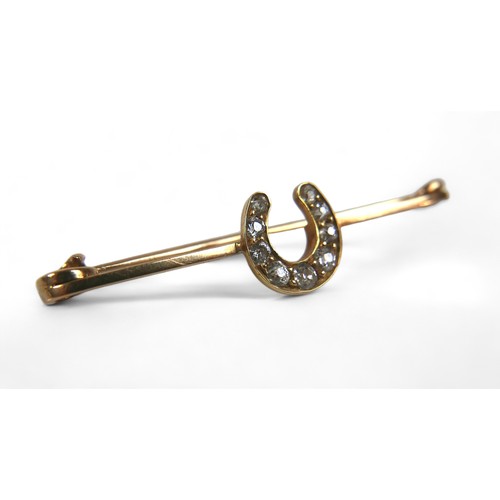 124 - Three gold brooches, comprising a platinum 15ct yellow gold riding crop, 6cm long, a diamond horsesh... 