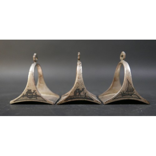 16 - A set of six Egyptian niello white metal stirrup shaped napkin rings, each 5 by 4 by 6cm high. (6)