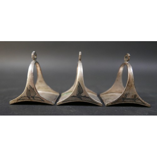 16 - A set of six Egyptian niello white metal stirrup shaped napkin rings, each 5 by 4 by 6cm high. (6)