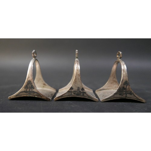 16 - A set of six Egyptian niello white metal stirrup shaped napkin rings, each 5 by 4 by 6cm high. (6)