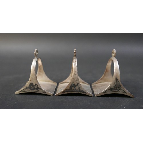 16 - A set of six Egyptian niello white metal stirrup shaped napkin rings, each 5 by 4 by 6cm high. (6)