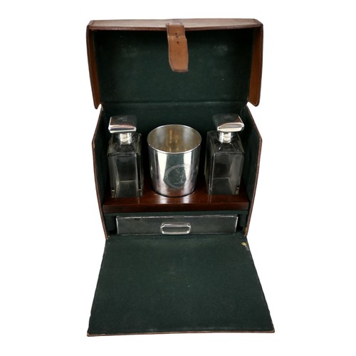 388 - A tan leather gentleman's travel case with a fitted interior containing a pair of silver hunting top... 