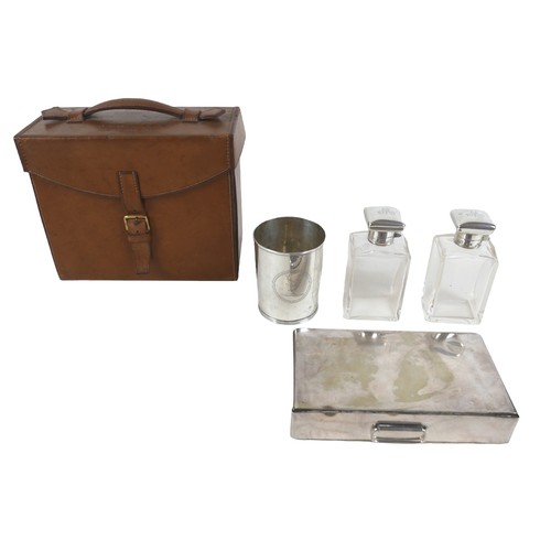 388 - A tan leather gentleman's travel case with a fitted interior containing a pair of silver hunting top... 