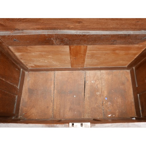 533 - An 18th century carved oak coffer, two plank top with loop hinges, three panel front with scrolling ... 