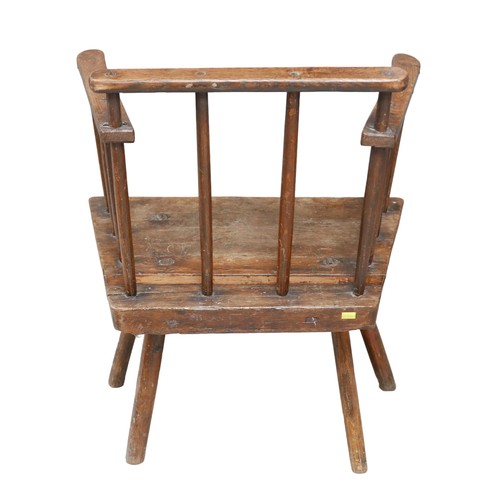 523 - A low 18th century oak armchair, stick back, short legs, 56 by 41 by 69.5cm high.