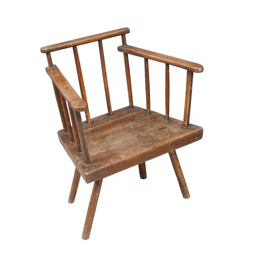 523 - A low 18th century oak armchair, stick back, short legs, 56 by 41 by 69.5cm high.