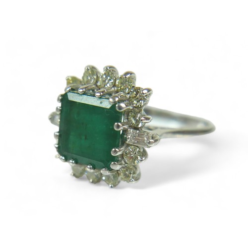 147 - A square-cut emerald and diamond ring, the central dark green emerald approx 8mm by 8mm, surrounded ... 