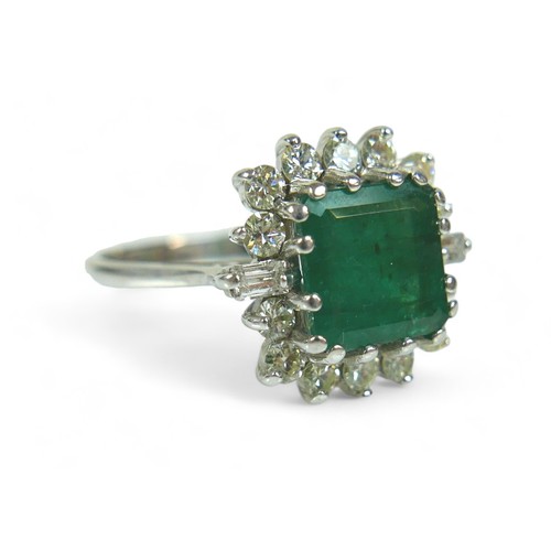 147 - A square-cut emerald and diamond ring, the central dark green emerald approx 8mm by 8mm, surrounded ... 