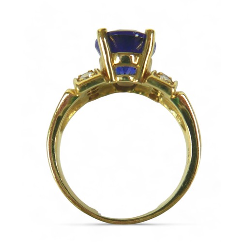 141 - A tanzanite, diamond and 18k gold ring, the large blue oval cut central tanzanite flanked by eight b... 