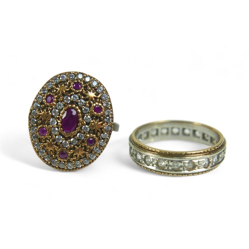 97 - A ruby and clear stone ring, the oval and round-cut rubies alternating with rings of clear stones an... 