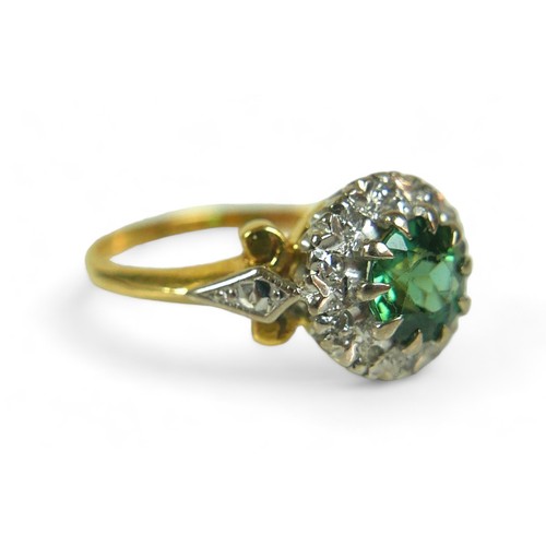 130 - A diamond and green stone flowerhead cluster ring, possibly green tourmaline, the round-cut central ... 