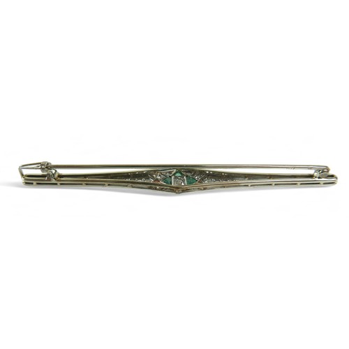 148 - An Art Deco diamond and emerald bar brooch, on 18ct gold and platinum setting, the central round cut... 