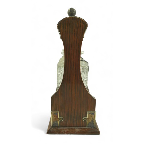 286 - A Victorian oak tantalus, with EPNS mounts and carved decoration, containing three clear glass part ... 