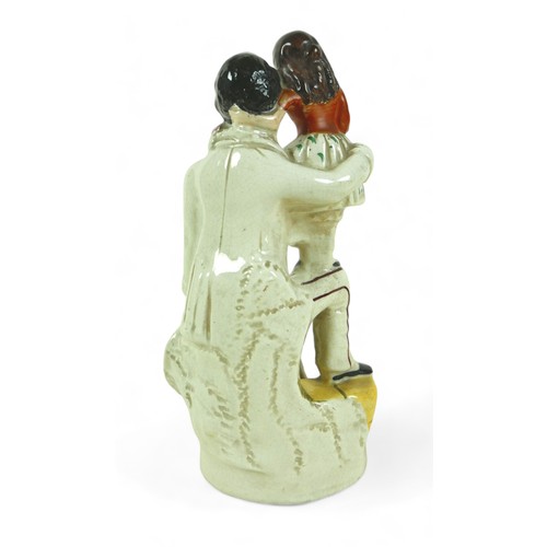 213 - A Victorian Staffordshire figure group, 'Uncle Tom', 26.5cm high, together with a Royal Doulton twin... 