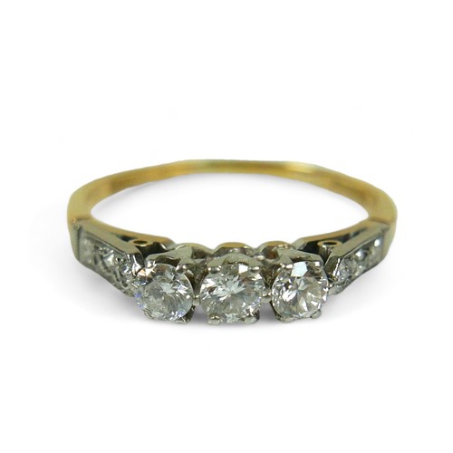 136 - An 18ct gold three stone diamond ring, with additional small diamonds to the shoulders, size U, the ... 