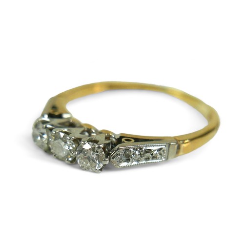 136 - An 18ct gold three stone diamond ring, with additional small diamonds to the shoulders, size U, the ... 