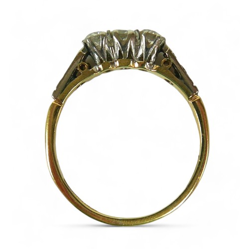 136 - An 18ct gold three stone diamond ring, with additional small diamonds to the shoulders, size U, the ... 