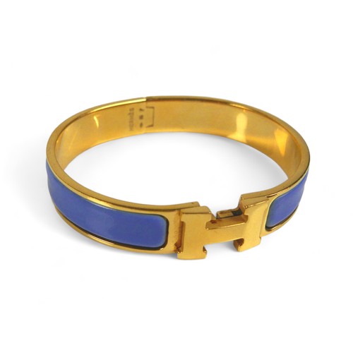 117 - A Hermes Clac H gold plated hinged bangle, with blue enamel details, H design clasp.