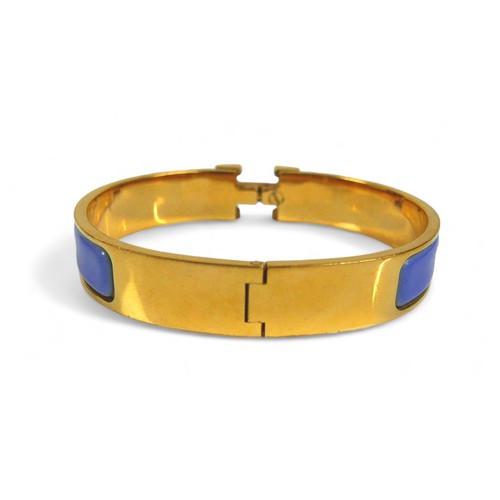 117 - A Hermes Clac H gold plated hinged bangle, with blue enamel details, H design clasp.