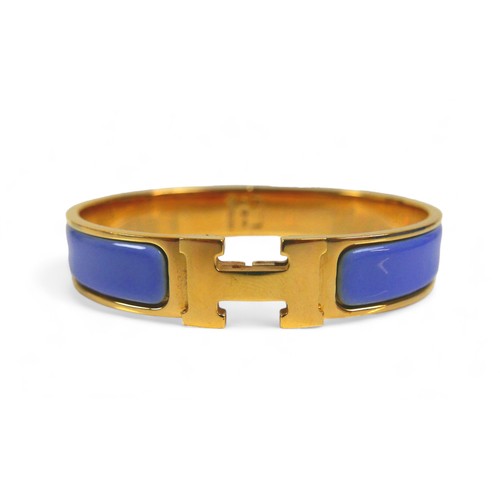 117 - A Hermes Clac H gold plated hinged bangle, with blue enamel details, H design clasp.