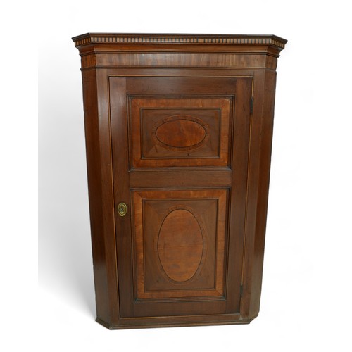 528 - A George lll mahogany corner cupboard inlay with rosewood and satinwood, the single door enclosing t... 