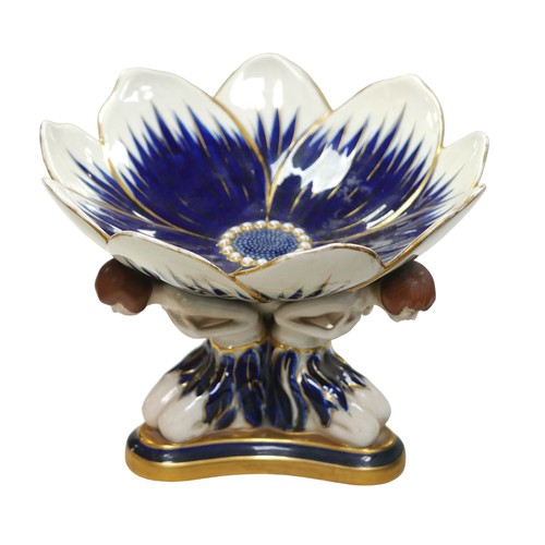 219 - A Royal Dux Art Deco tazza, with a flowerhead top and three kneeling flapper figures to its base, 24... 