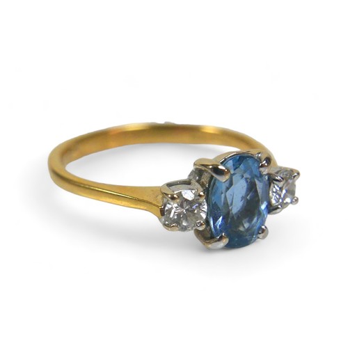 80 - An 18ct gold blue topaz and diamond ring, the oval cut blue stone, 4 by 7mm, size K/L, 2.6g.