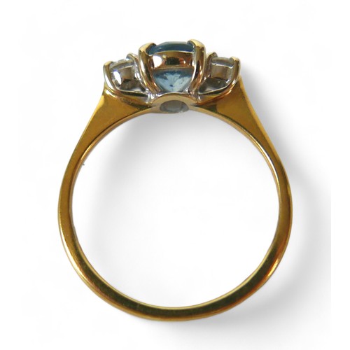 80 - An 18ct gold blue topaz and diamond ring, the oval cut blue stone, 4 by 7mm, size K/L, 2.6g.