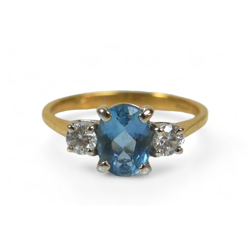 80 - An 18ct gold blue topaz and diamond ring, the oval cut blue stone, 4 by 7mm, size K/L, 2.6g.