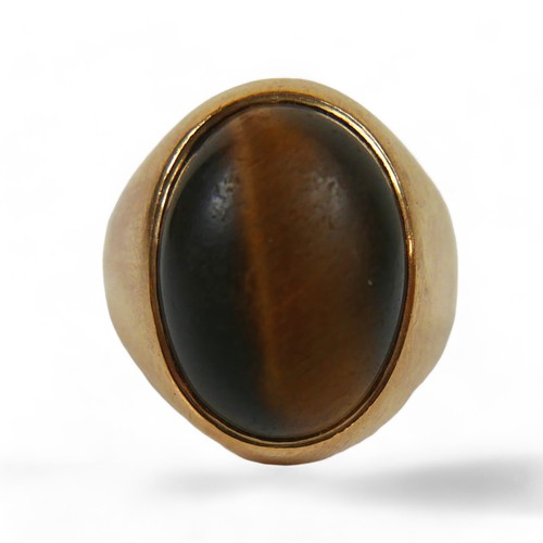 128 - A yellow gold signet ring, set with a cabochon tiger's eye, 20 by 26 by 19mm, size P, 12.7g, surface... 