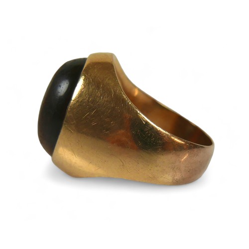 128 - A yellow gold signet ring, set with a cabochon tiger's eye, 20 by 26 by 19mm, size P, 12.7g, surface... 