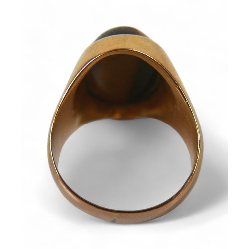 128 - A yellow gold signet ring, set with a cabochon tiger's eye, 20 by 26 by 19mm, size P, 12.7g, surface... 