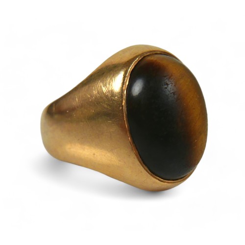 128 - A yellow gold signet ring, set with a cabochon tiger's eye, 20 by 26 by 19mm, size P, 12.7g, surface... 