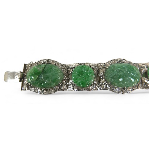 104 - A Chinese white metal and carved jade six panel bracelet, with push clasp, 19cm long when open.