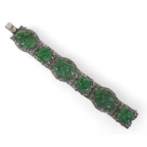 104 - A Chinese white metal and carved jade six panel bracelet, with push clasp, 19cm long when open.