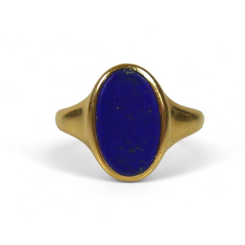 131 - A George V 18ct gold and lapis lazuli signet ring, with flat oval central stone, 12 by 7mm, London 1... 